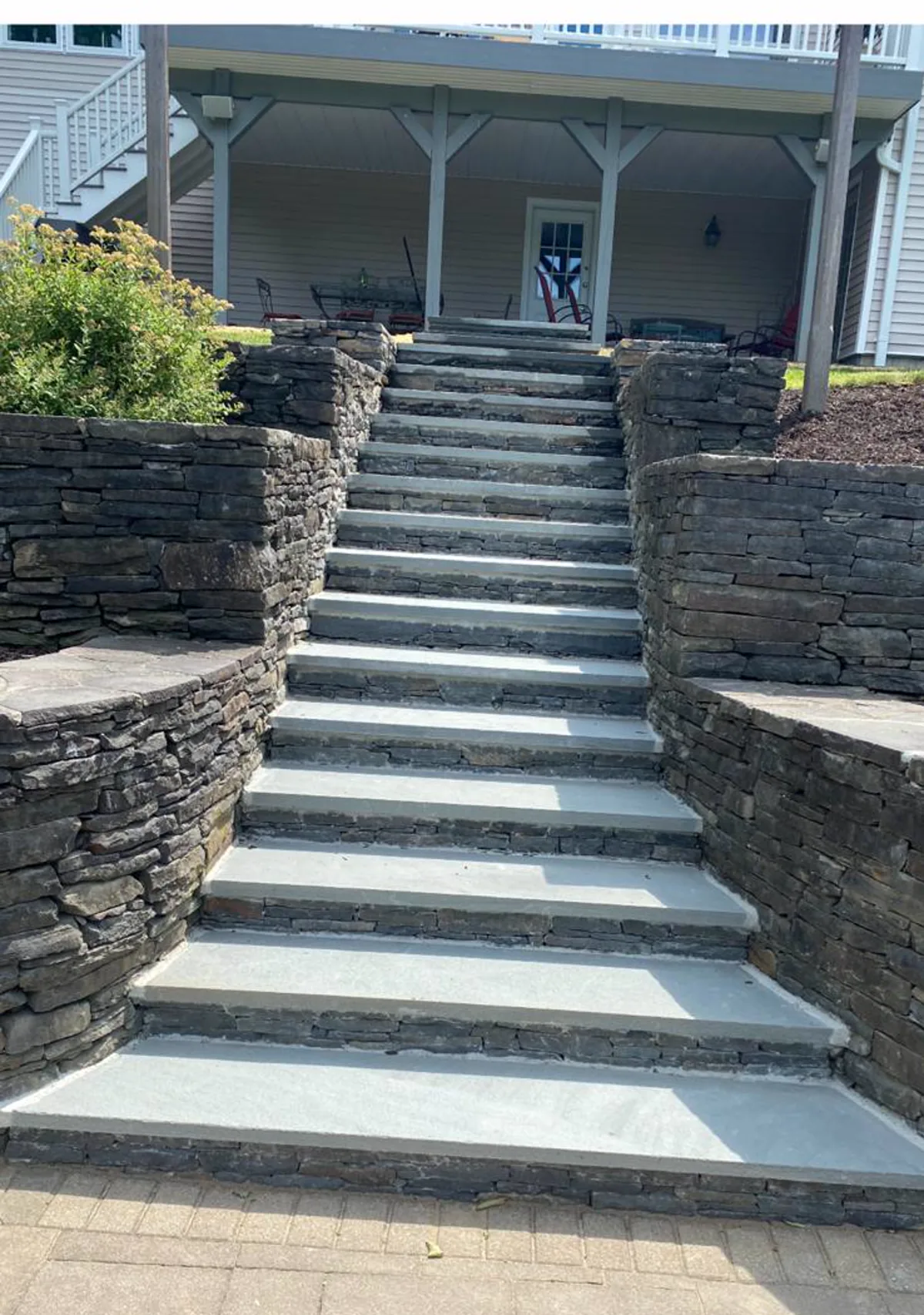 Outdoor stone stairs between natural stone retaining walls